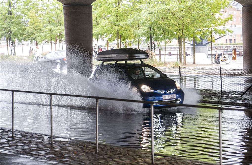 bil kører gennem kæmpe vandpyt
