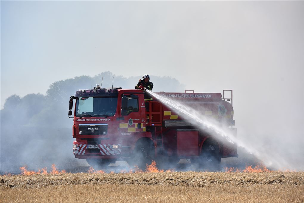 En brandbil slukker en markbrand