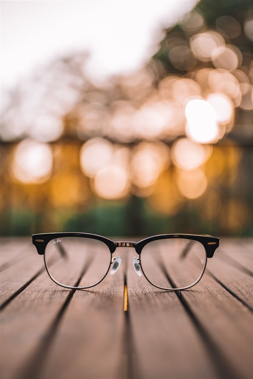 Et par briller ligger på et havebord