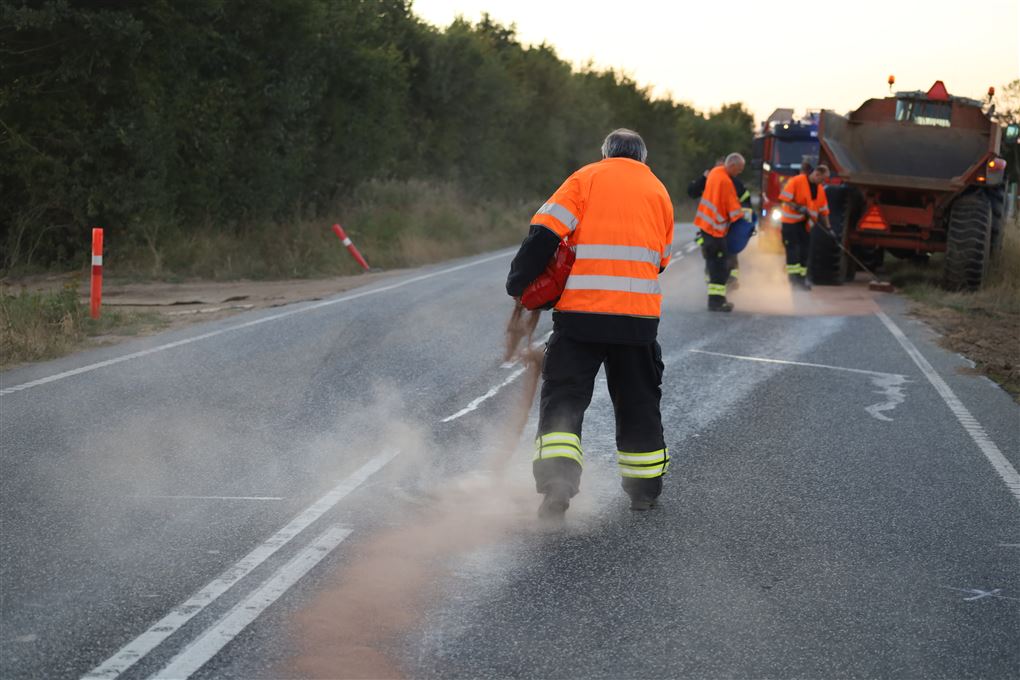 mænd strør kattegrus på vej