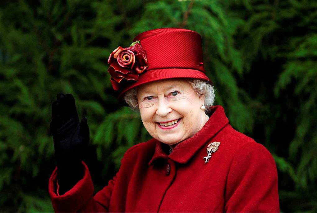 Dronning Elizabeth smiler med hat på