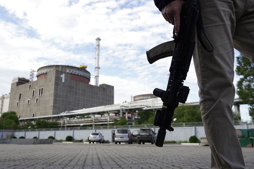 En bevæbnet vagt står udenfor atomkraftværket Zaporizjzja i Ukraine.