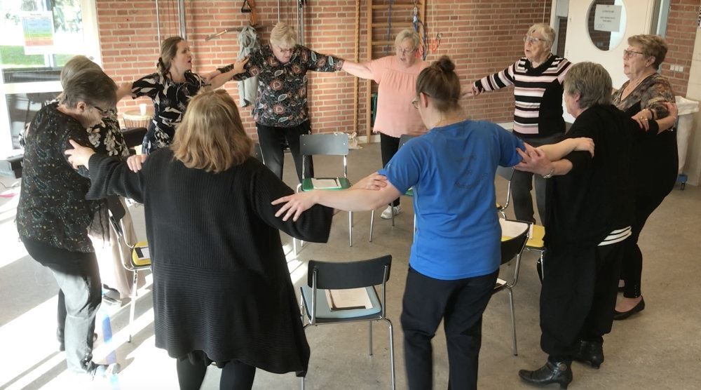 folk i rundkreds synger