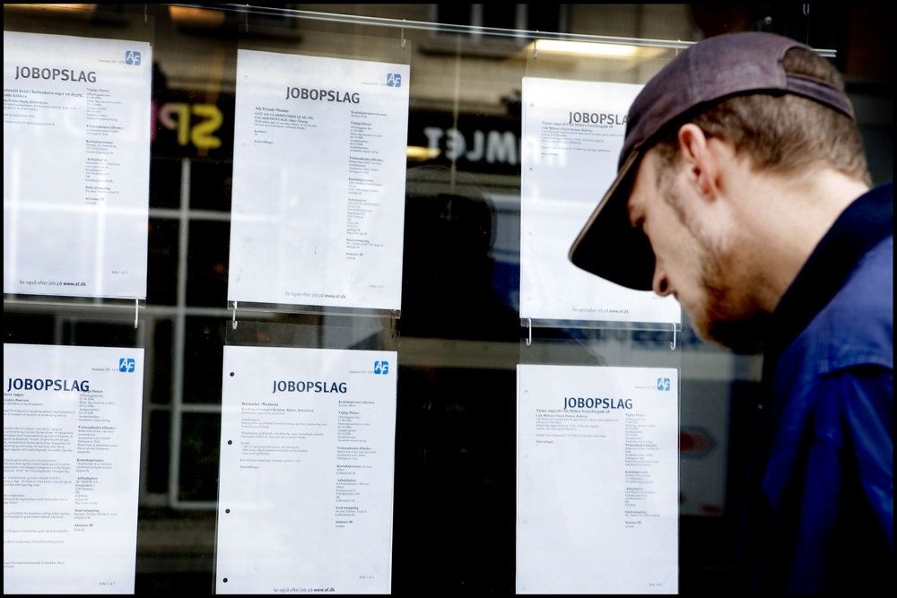 et jobopslag, som en mand kigger på igennem et vindue