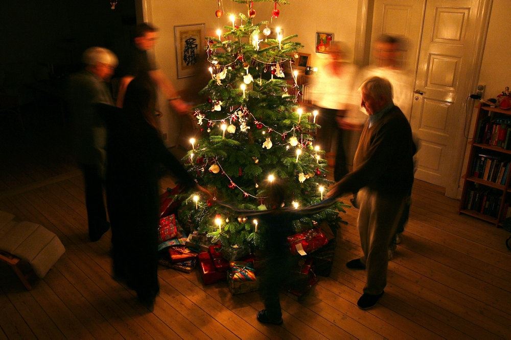 En familie danser rundt om juletræet