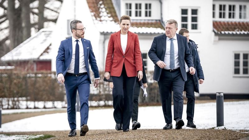 tre mennesker spadserer mod kameraet