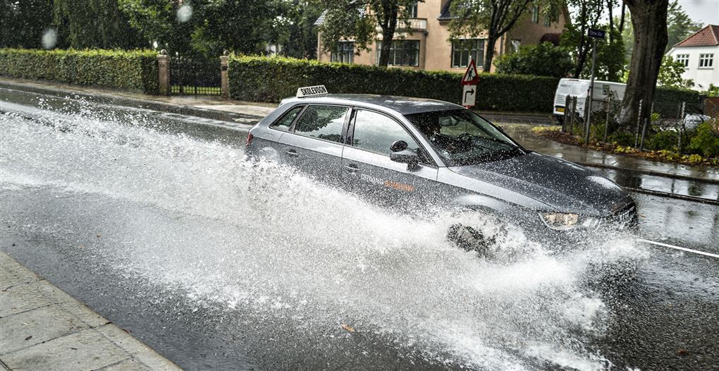 bil kører i voldsomt regnvejr