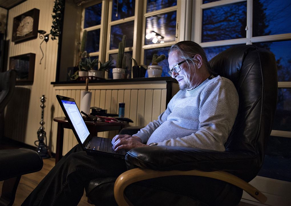 mand sidder i lænestol og skriver på computer