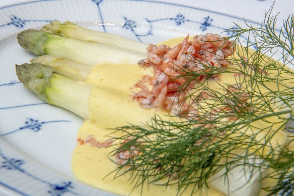 Hvide asparges anrettet på en musselmalet tallerken