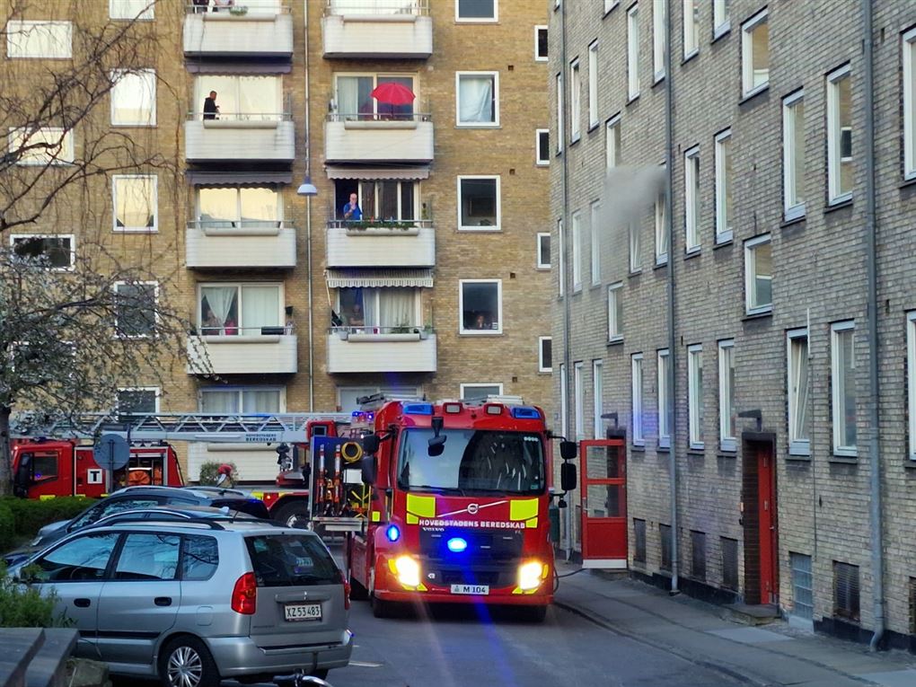 Brandbil med udrykning foran en beboelsesblok