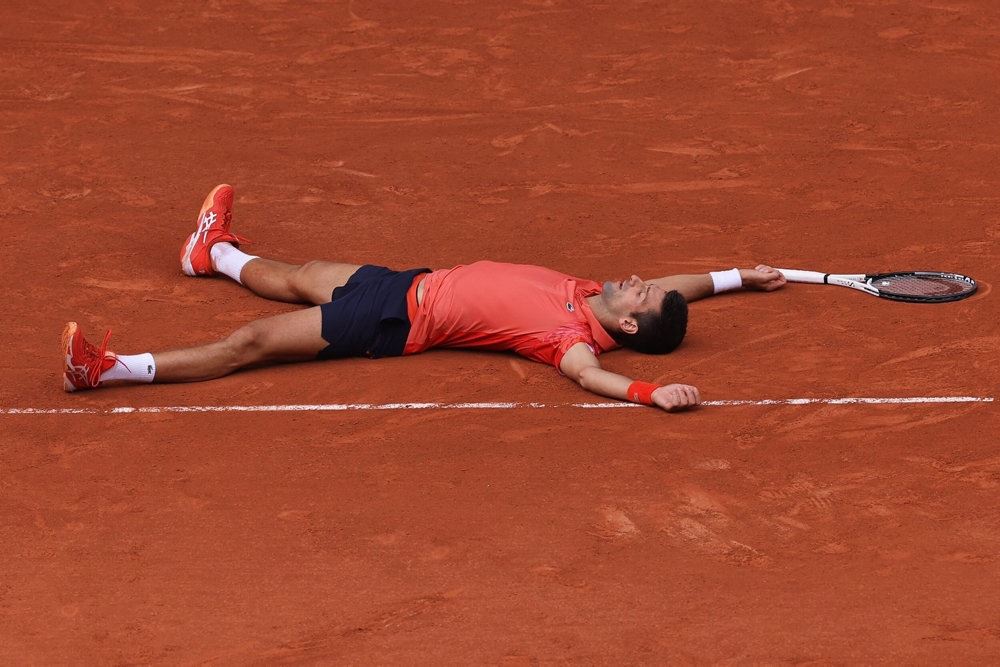 tennisspiller ligger på banen efter sejr