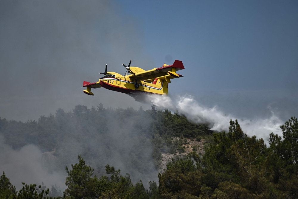 Et fly hælder vand ud over en skovbrand