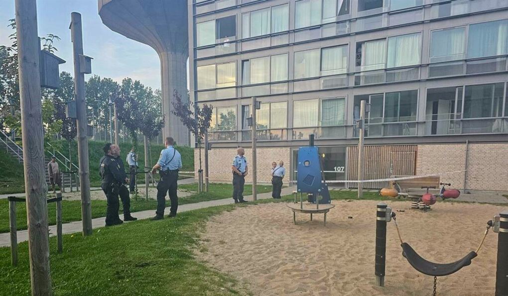 Flere politibetjente ved en legeplads i et boligområde