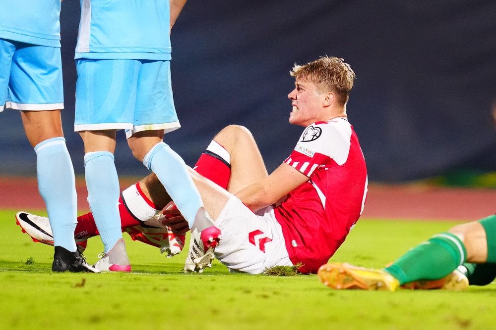 en fodboldspiller ømmer sig på banen