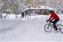 En mand cykler i sne