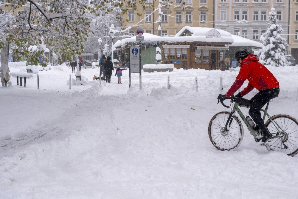 En mand cykler i sne