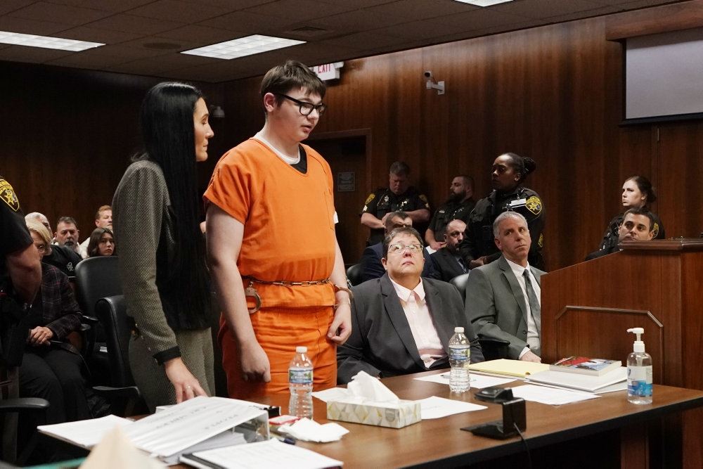 mand i orange fangedragt står i retssal