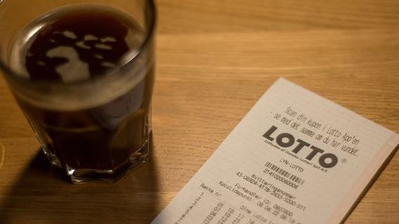 Lottokupon og kaffekrus på bord