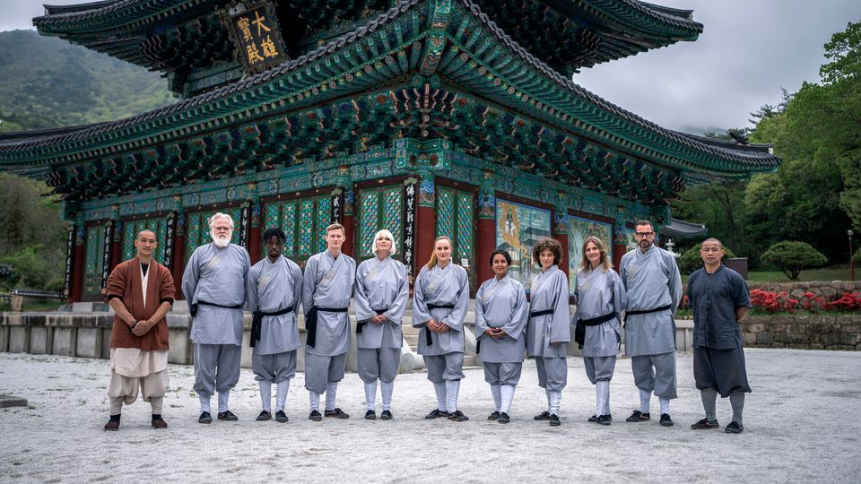 11 personer poserer foran tempel