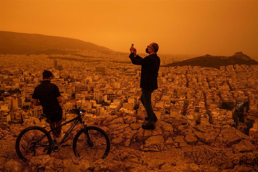 en mand tager billeder af en rød by