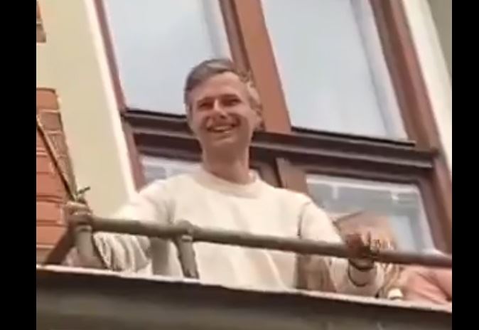 mand på balkon smiler 