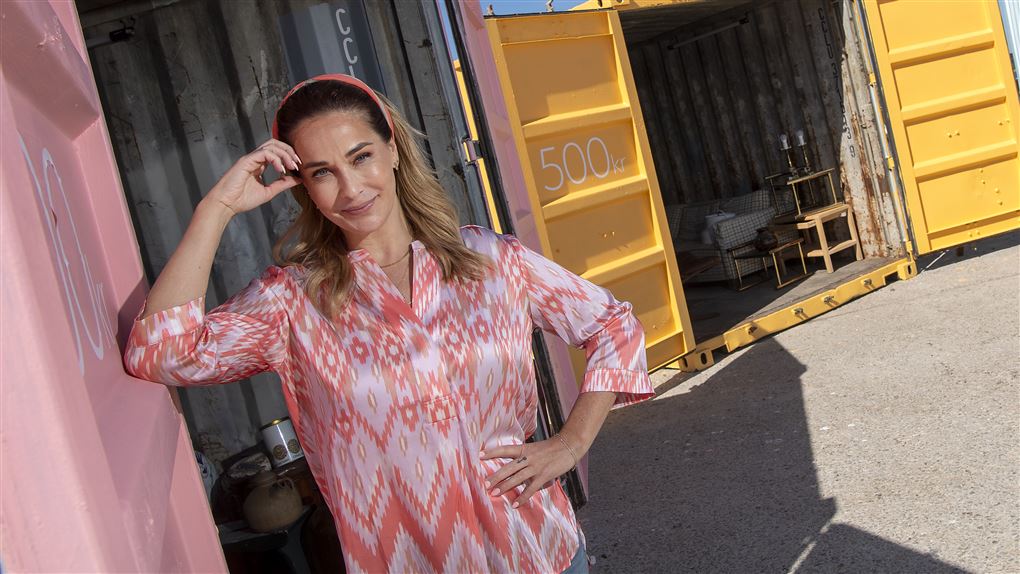 en kvinde læner sig op ad en container