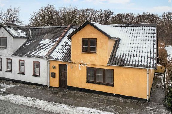 gult hus med sne på taget