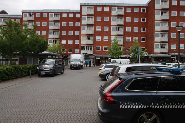 udrygningskøretøjer foran høj bygning