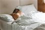 kvinde ligger i seng i sover