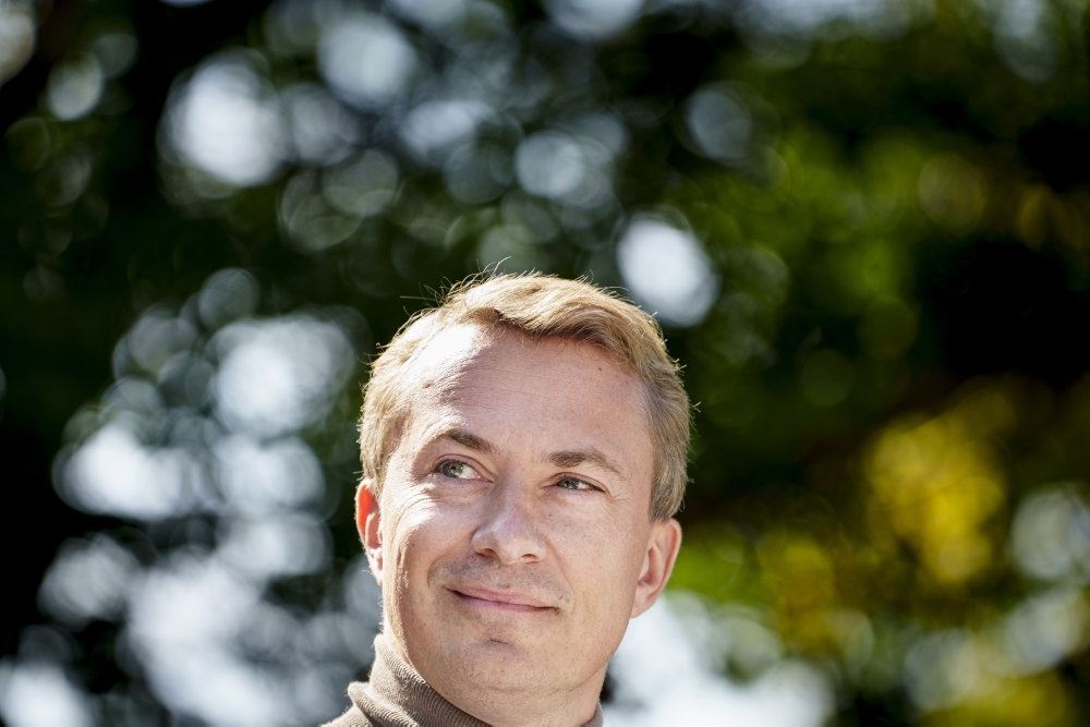 Morten Messerschmidt smiler under et træ.
