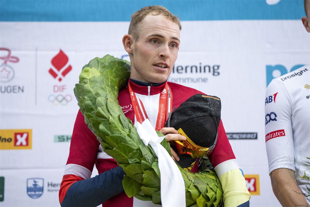 Mattias Skjelmose i DM-trøje og med laurbærkrans om halsen efter