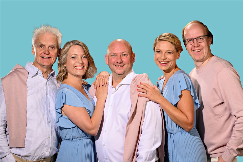 fem personer smiler til fotografen