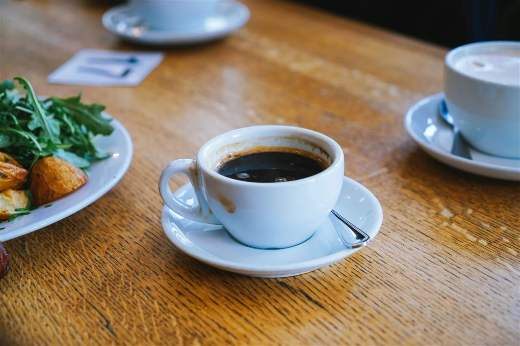 kaffekop med kaffe står på bord