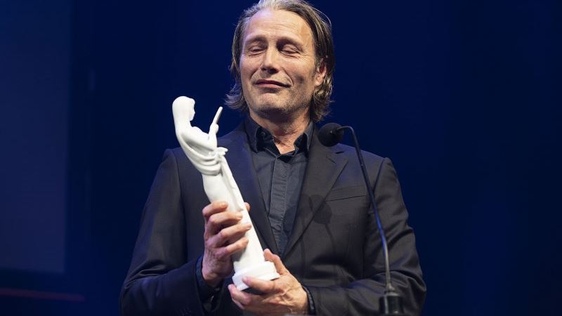 kvinde står med statuette