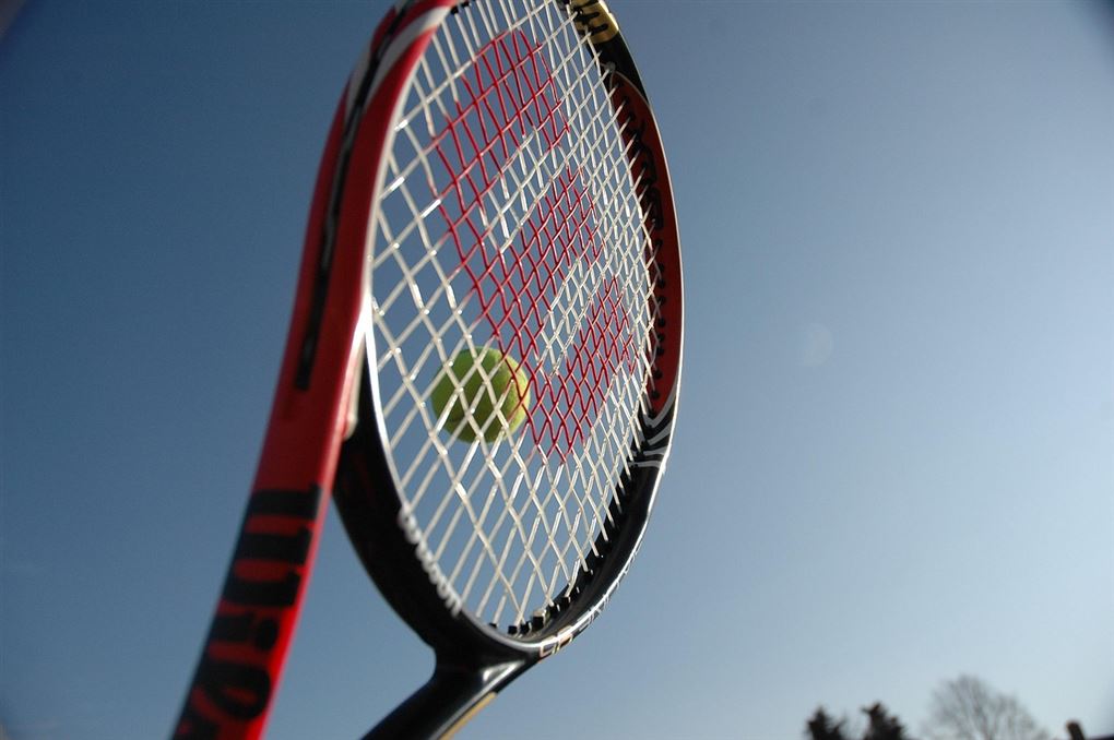 en tennisketcher i luften