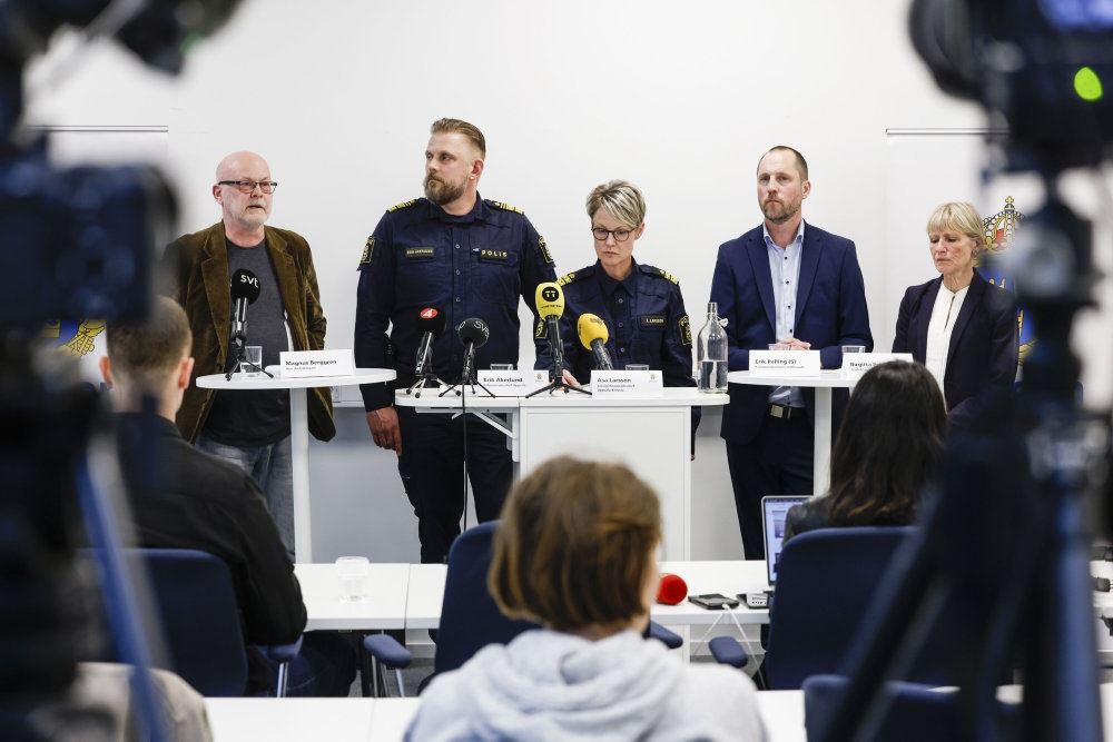 ordenspersoner holder pressemøde bag høje borde