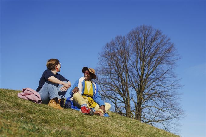 folk sidder udenfor i solen