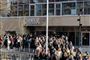 folk i kø for at komme ind på skole