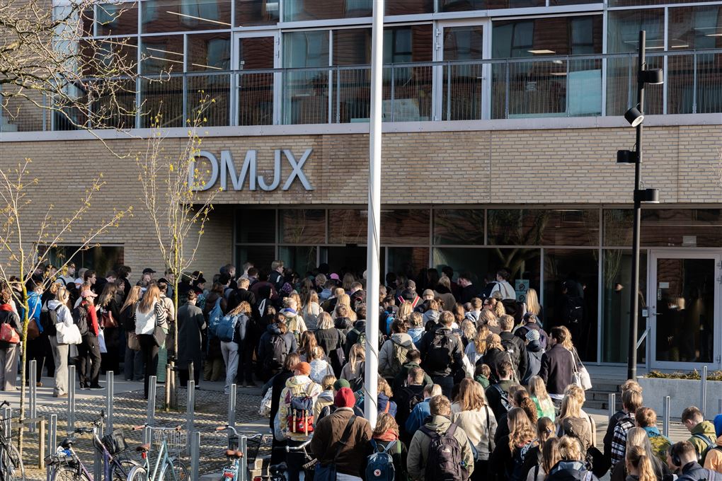 folk i kø for at komme ind på skole