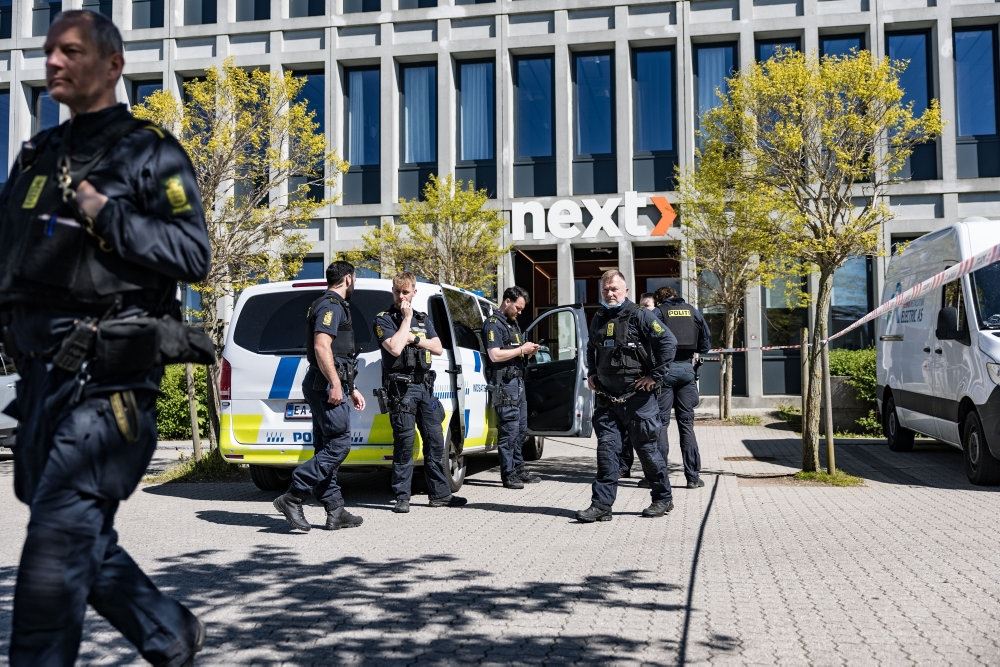 politibil med betjente foran bygning