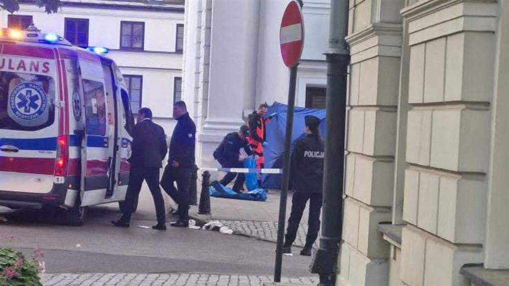 Politifolk og ambulance ved bygning
