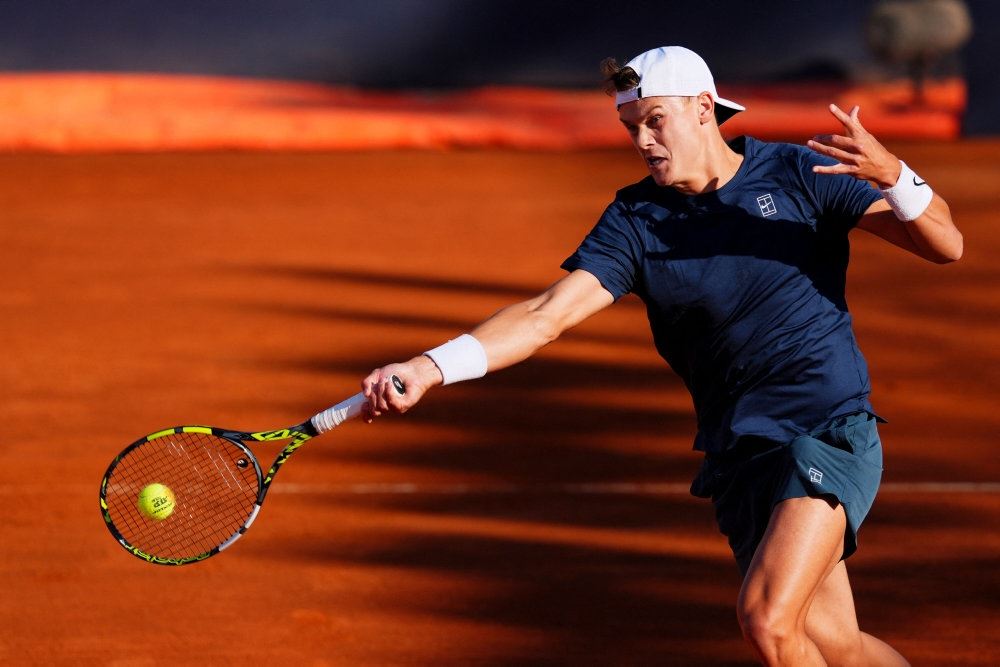 Mand i mørkt tennistøj og hvid kasket