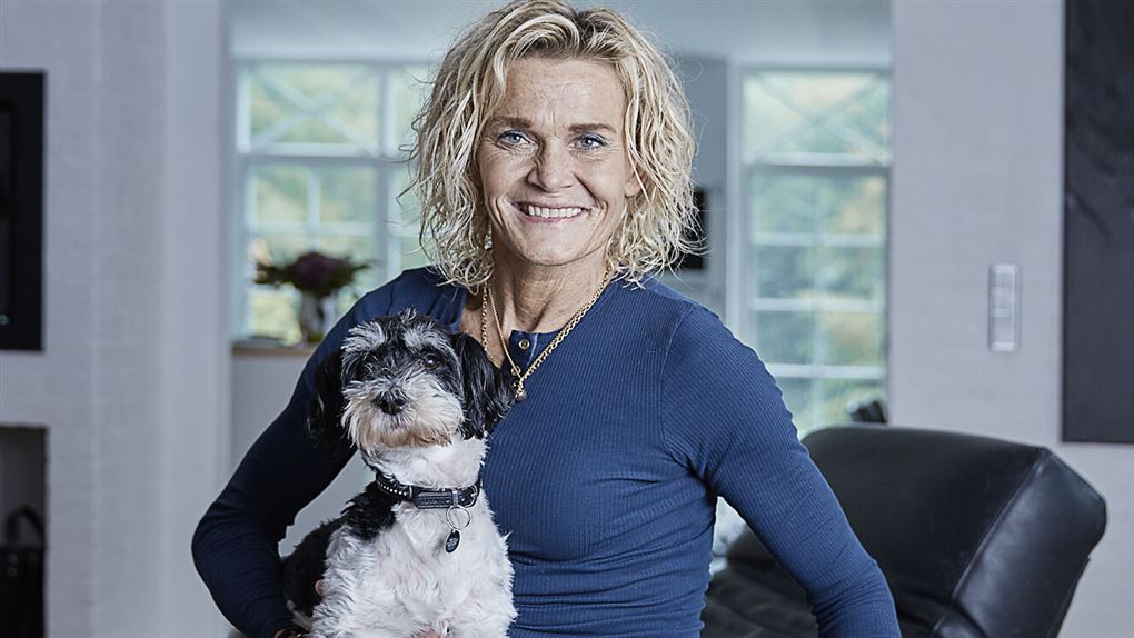 en smilende kvinde med en hund