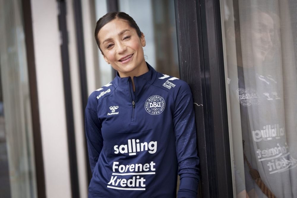 kvindelig smilende fodboldspiller i blåt