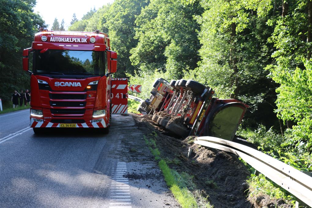 falckbil holder ved siden af væltet lastbil