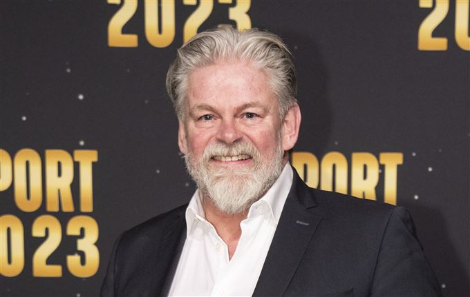 en mand smiler til fotografen