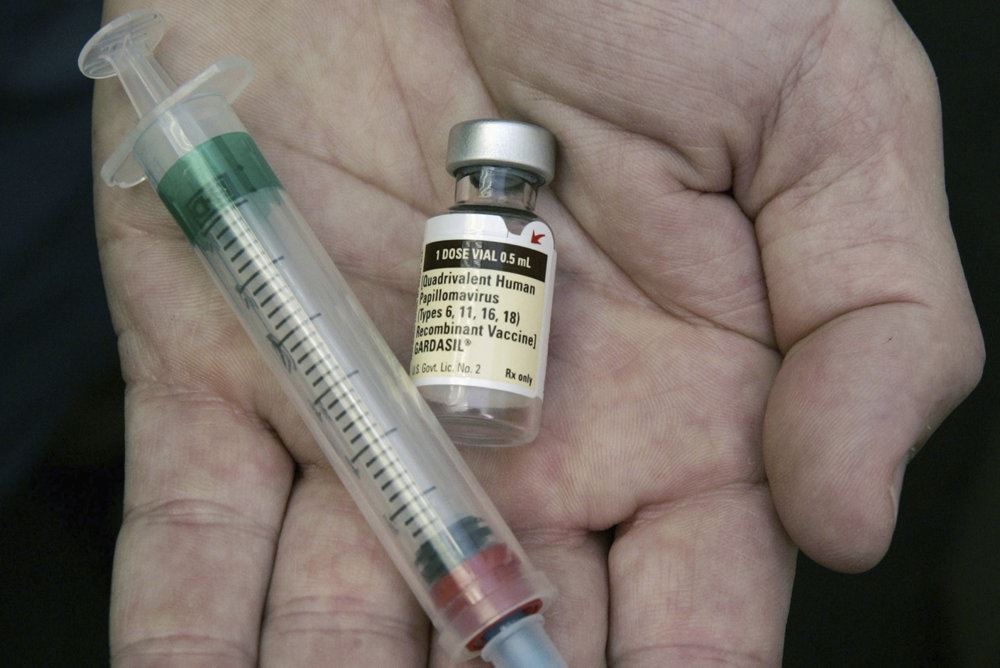 En hånd holder en sprøjte og vaccine