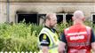 politi og brandfolk foran det brandramte hus