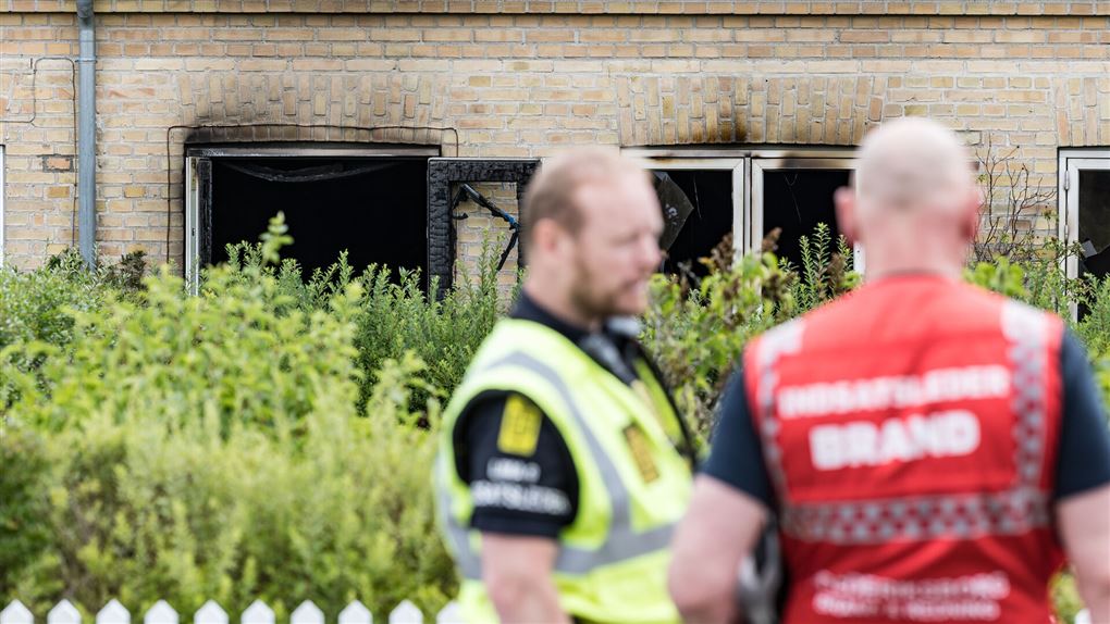 politi og brandfolk foran det brandramte hus