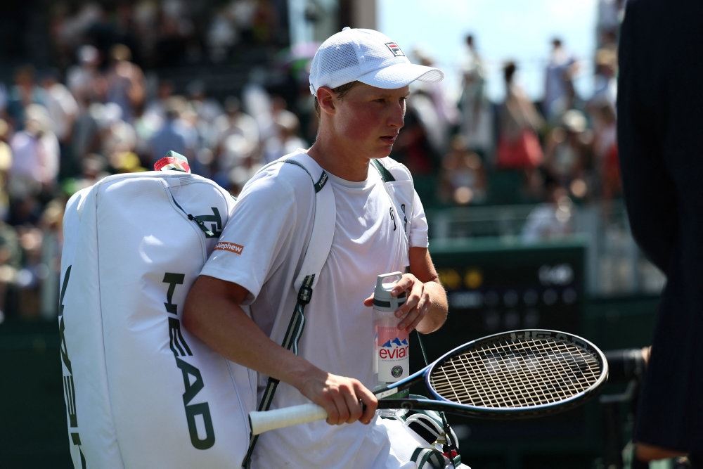 tennisspiller går med taske og ketcher